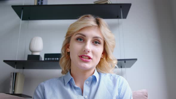 Happy woman talking at laptop by video link in office