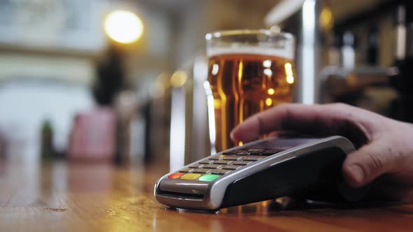 Buying Beer and Paying By Smartphone Closeup