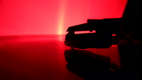 Vinyl Record Spins on an Old Turntable Illuminated By Red Lights