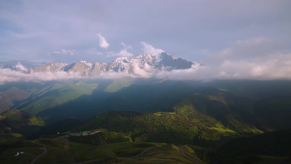 Timelapse of Evening Mountains in Summer with Green Grass and Flowing Clouds on a Telephoto Lens