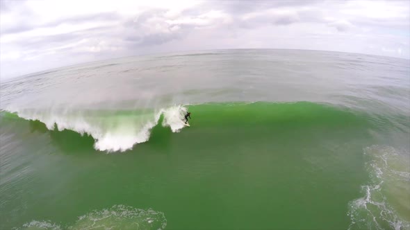 Aerial view of a surfer riding a wave while surfing