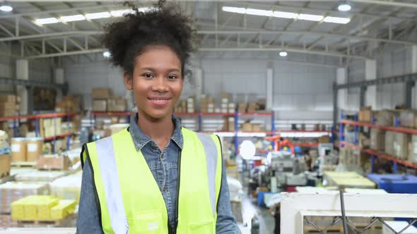 Female warehouse worker counting items in an industrial warehouse