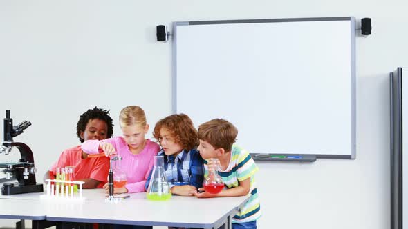 Kids doing a chemical experiment in laboratory