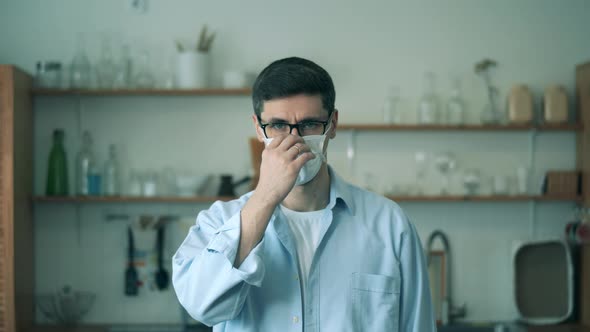 Portrait of a Man on Quarantine Is Putting on His Face Mask. Man at Home During Covid-19 Coronavirus