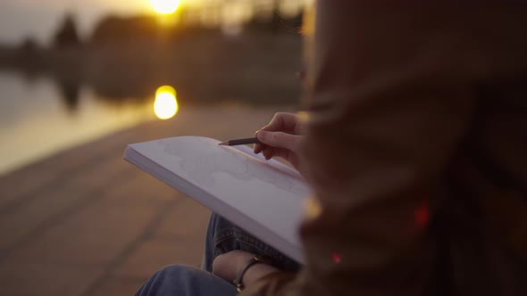 Unrecognizable Girl Sketching at Sunset