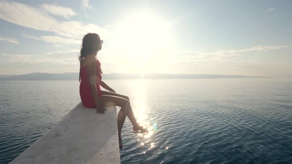 A Young Woman Sitting on the Edge of a Boat with Beautiful View of Sunlight.