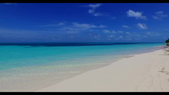 Aerial drone shot texture of tranquil coastline beach voyage by blue lagoon and white sand backgroun