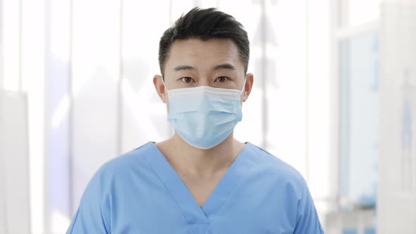 Crop View of Asian Man in Medical Protective Mask Raising Head and Looking to Camera