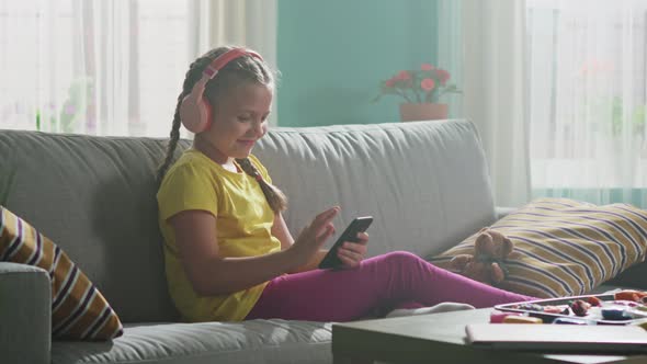 Small Girl Is Using Mobile Phone To Surf in the Internet