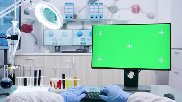 POV Shot of Chemist in White Coverall Typing on Computer Keyborad with Green Screen Mock-up