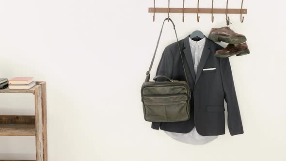 Close-up of blazer, shoes, and bag hanging on hook