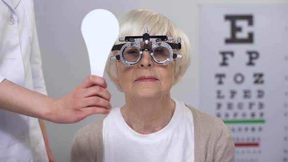 Ophthalmologist Closing Senior Lady in Phoropter Eye
