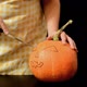 A Woman Carves a Scary Face in a Pumpkin - VideoHive Item for Sale
