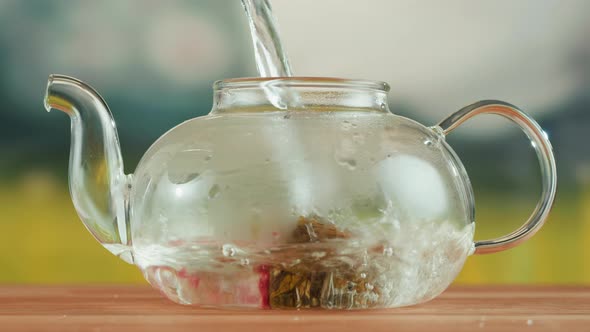 Pouring Hot Water Into Teapot with Bound Tea Closeup