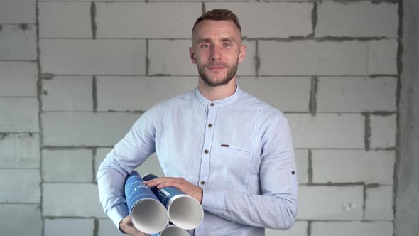 Portrait of a builder with blueprints in his hands