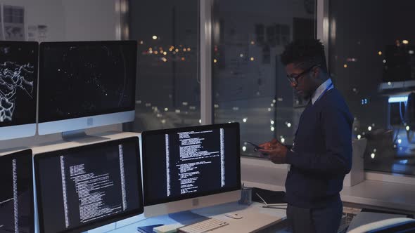 Programmer Using Smartphone at Night