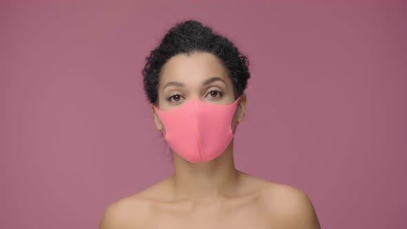 Beauty Portrait of Young African American Woman in Pink Protective Pitta Mask Looking at Camera