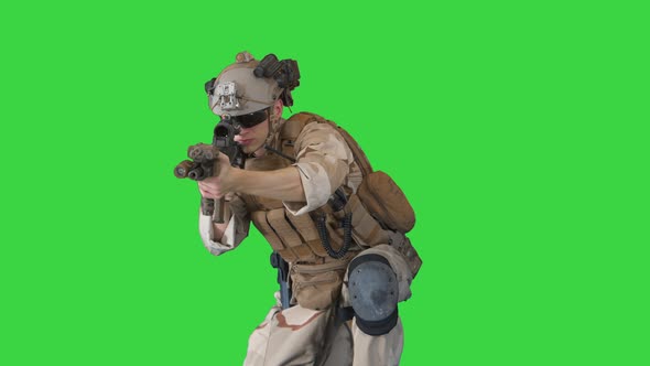 US Military Marine Shooting From Sitting Position on a Green Screen, Chroma Key.