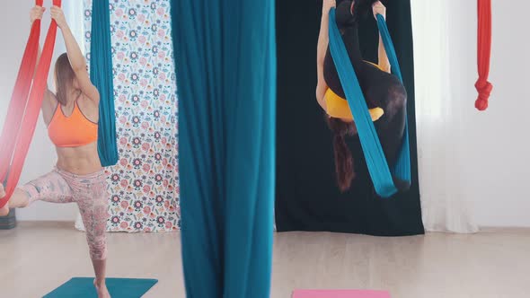 Aerial Yoga - Two Women Having a Training - Getting on the Hammock with One Leg