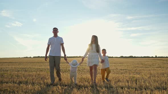 Family Father Mother and Small Children Sons Walk Joining Hands