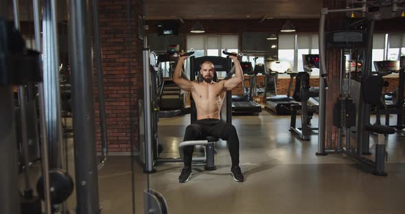 Sportsman with Bare Torso and Pumping Shoulder Girdle Shoulder Limb Muscles Gym