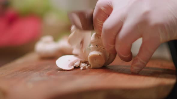 Closeup of chef chopping mushrooms in the kitchen