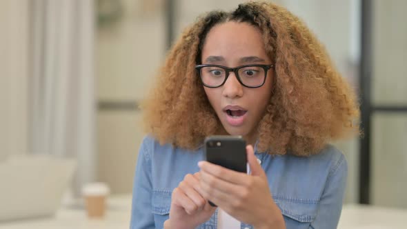 Portrait of African Woman Celebrating on Smartphone