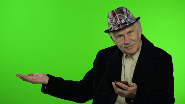 Elderly Caucasian Grandfather Using Smartphone, Pointing at Something with Hand