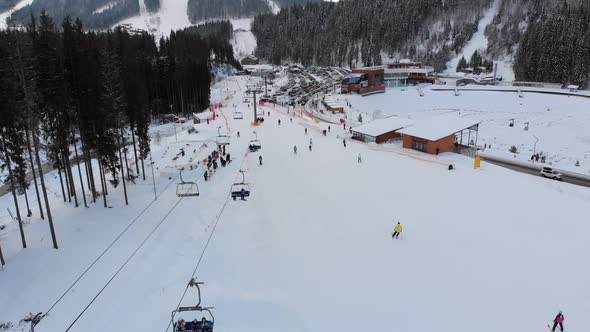 Aerial View of a Ski Resort with Parking for Cars. Ski Slopes and Ski Lifts in Winter