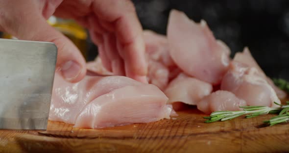 Men's Hands with Knife Cut Raw Chicken Fillet Into Pieces