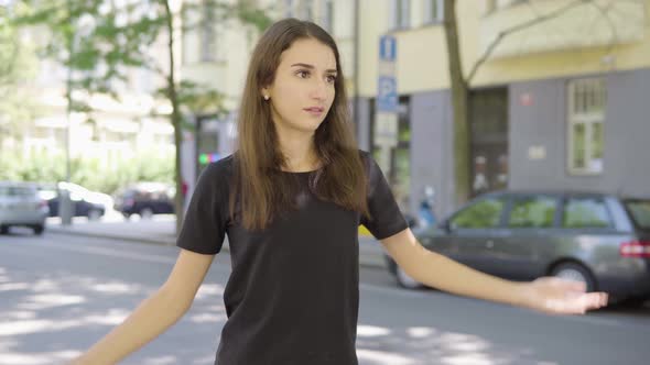 A Young Turkish Woman Acts Frustrated and at a Loss in the Street in an Urban Area