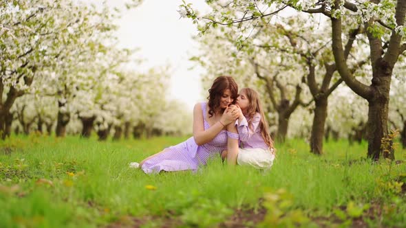 Family in Purple Clothe in Blossoming Spring Garden