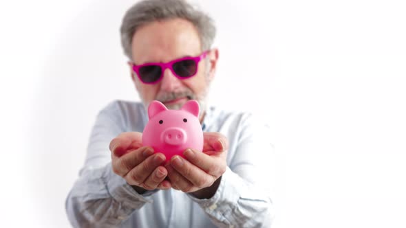 Gray Haired Man in His 40s Holding the Pink Piggy Bank  Investments and Happy Retirement Concept