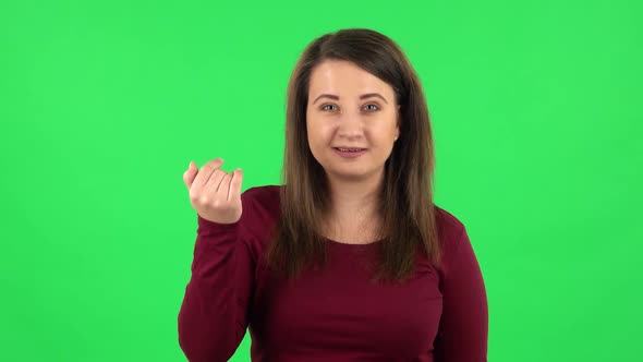 Portrait of Pretty Girl Waving Hand and Showing Gesture Come Here. Green Screen