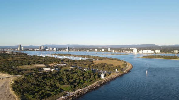 Busy shipping channel next to an open space parkland with a man made seaway rock wall and protected