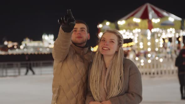 Young Couple Walking at Christmas Celebrating Outdoors