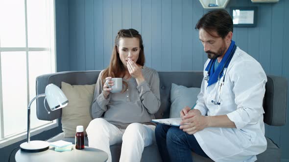 Pregnant Woman Visiting Doctor in Clinic. Closeup Belly Mother Taking Pills