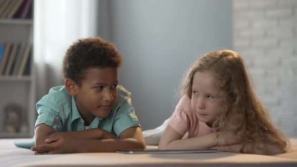 Afro-American Boy Glancing at Girl from Kindergarten During Watching Show