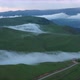 Drone Flight above green fields at the mountains in the clouds and fog. - VideoHive Item for Sale