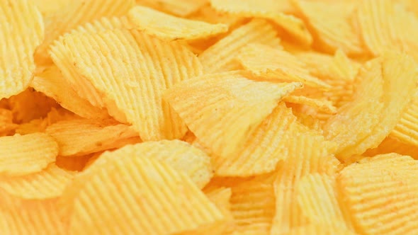 Looped Spinning Yellow Wavy Potato Chips Full Frame Closeup Background