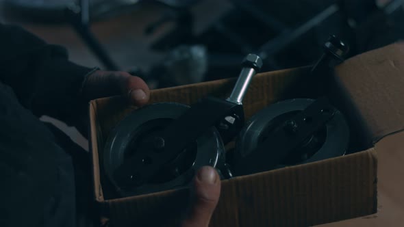 Side View of One American Male Workers in a Workshop at a Factory Making Wheelchairs Sitting at a