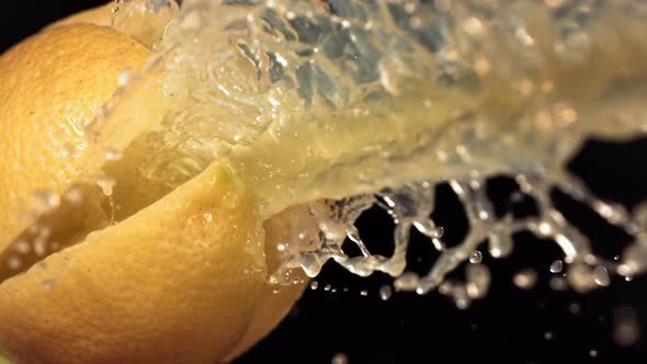 Fresh Lemon Fruit Squirting with Juice in Slow Motion in Black Background