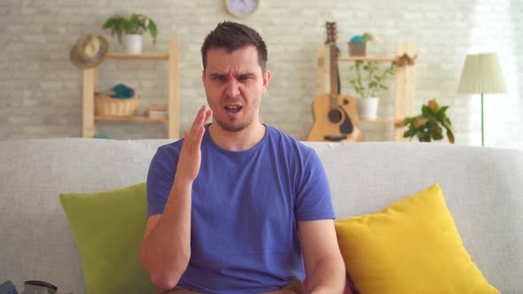 Young Man in a Modern Apartment Feels a Bad Smell and Puts on a Respirator