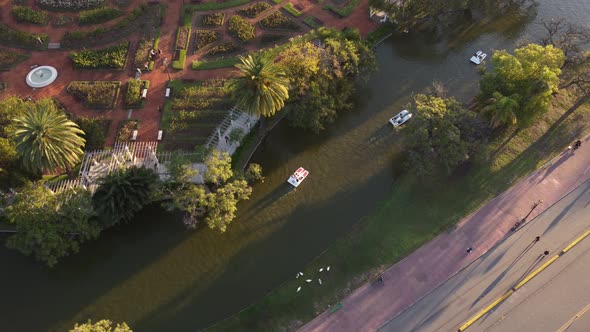 circular drone shot of the palermo lakes with pedal boats passing in buenos aires argentina