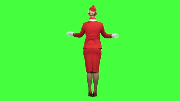 Stewardess Gestures Where the Emergency Exit Is. Green Screen. Back View