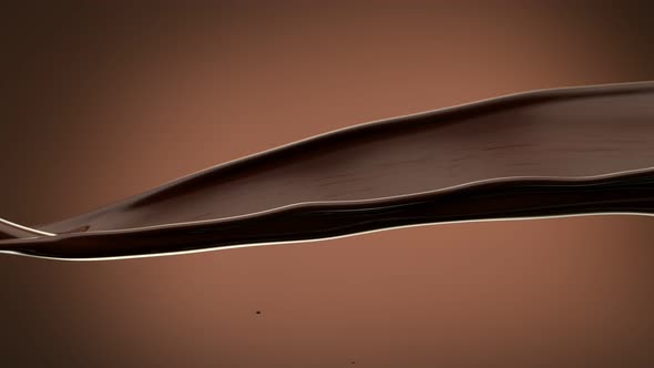 Super Slow Motion Shot of Waving Chocolate Splash on Brown Gradient Background at 1000 Fps