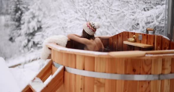 Woman Relaxing in Hot Vat at Mountains in Winter