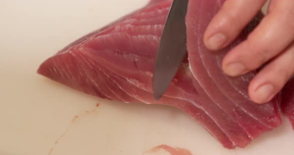 Slicing Raw Tuna Fish Using Butcher Knife. - Close Up Shot