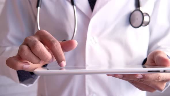 Doctor in White Coat Is Using a Digital Tablet