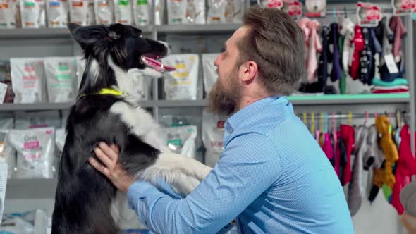 Happy Bearded Man Playing with His Dog at Veterinarian Office